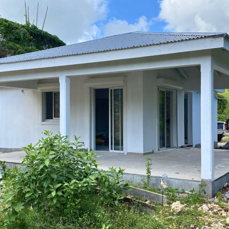 Villa Besson en cours de finalisation, avec terrasse couverte et ouvertures vitrées.