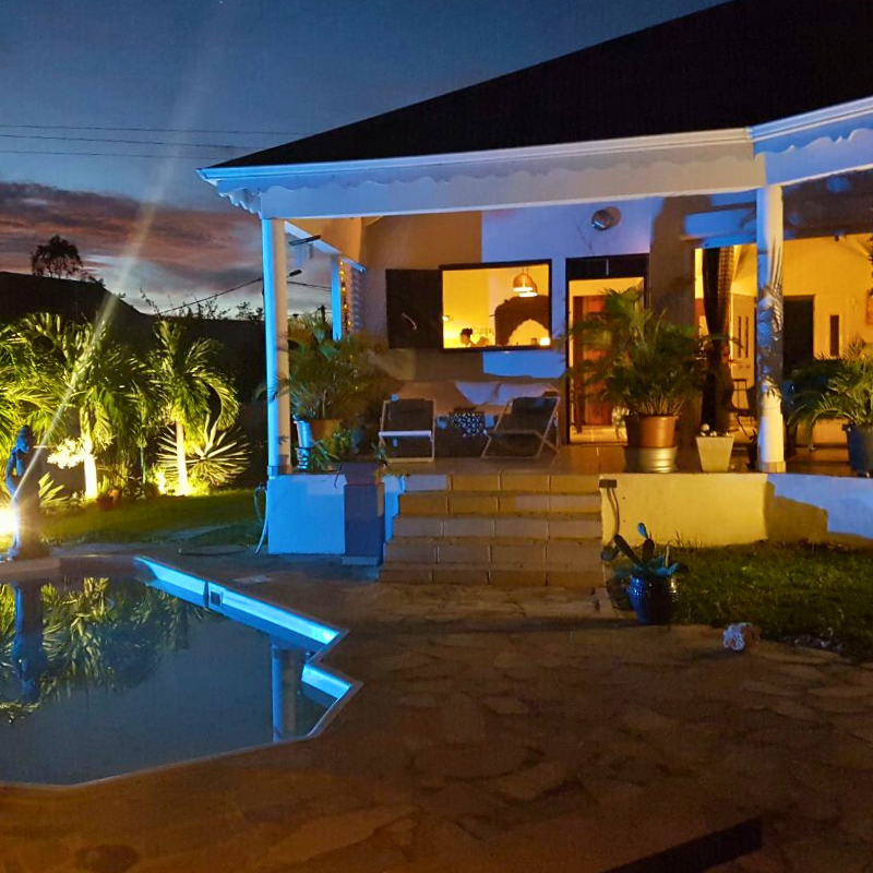 Terrasse couverte de la Villa Desplan avec piscine et plantes exotiques