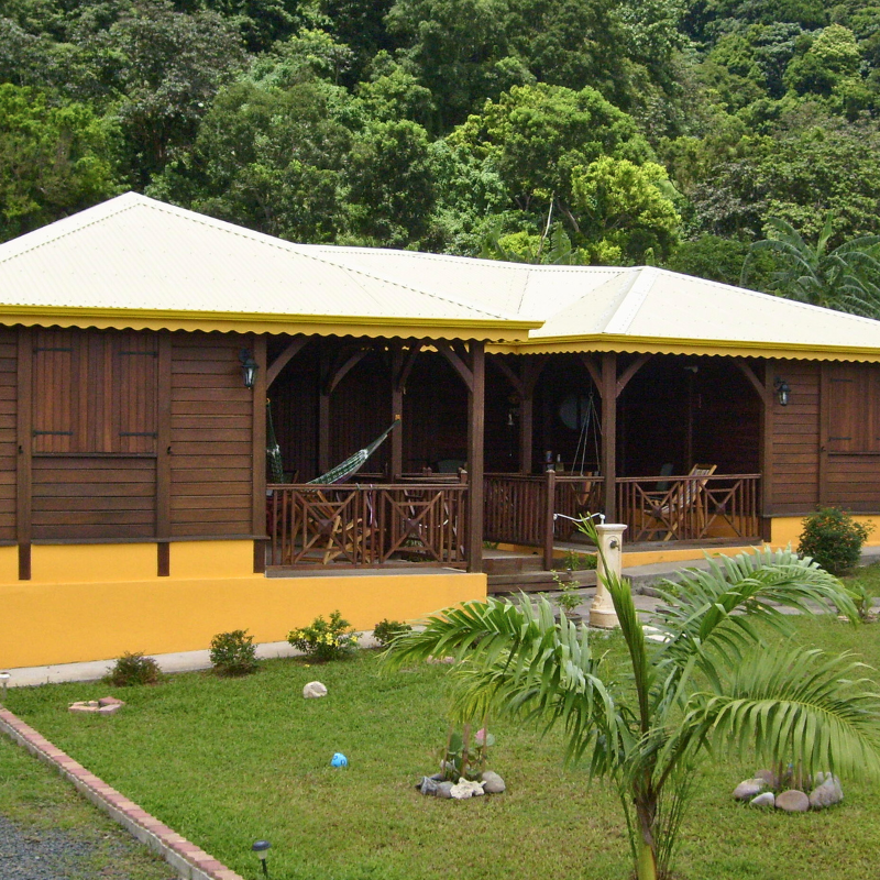 Vue extérieure de la Villa Jerent, une construction en bois avec une grande terrasse couverte.